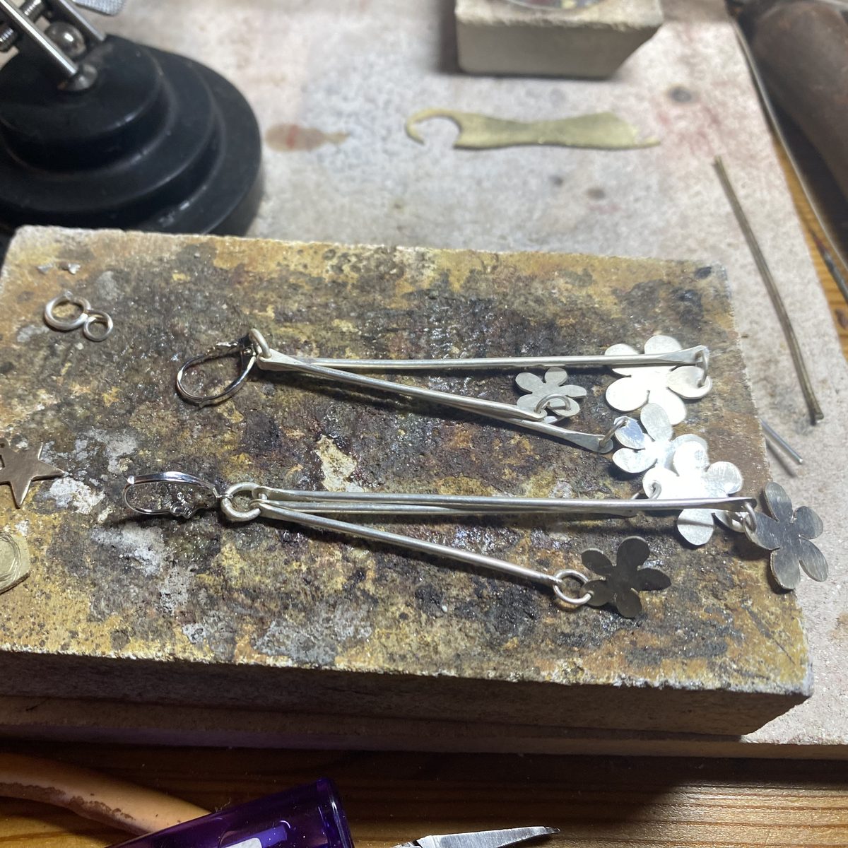 Flower drop earrings in progress on the soldering block